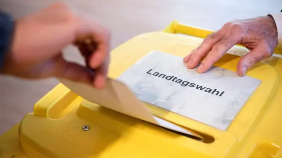 Eine gelbe Wahlurne, auf der ein Zettel mit dem Wort Landtags-Wahl liegt. | picture alliance/dpa/Sebastian Gollnow Eine gelbe Wahlurne, auf der ein Zettel mit dem Wort Landtags-Wahl liegt.